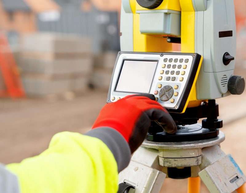 site-engineer-in-hiviz-working-on-house-building-construction-site-using-modern-surveying-equipment